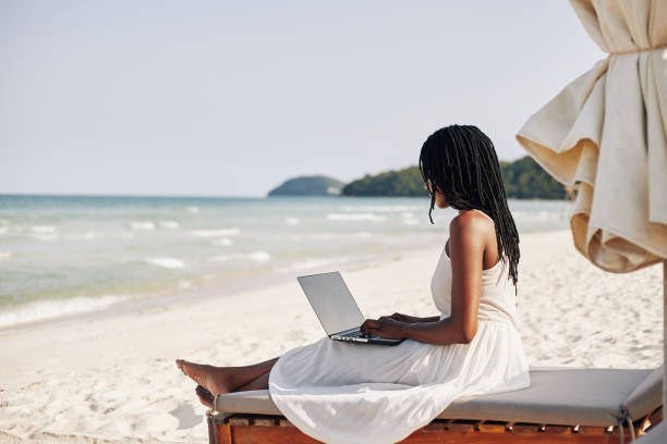 istock Woman resting on beach with laptop 1247604968