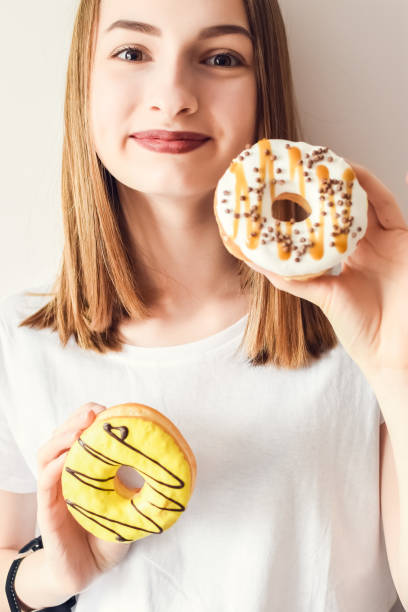 istock Beautiful girl holding donuts 1247633362