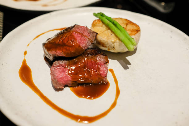 istock Medium Rare Prime Ribeye Steak with Black Sauce and Vegetable on Top 1247645315