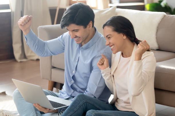 istock Excited young couple triumph reading email on laptop 1247647731
