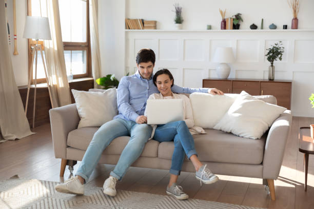 istock Happy Caucasian couple relax on couch using laptop 1247647741