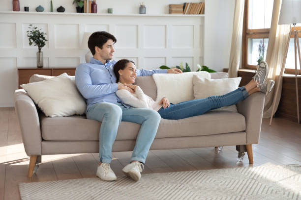 istock Happy young couple relax on couch hugging 1247647757