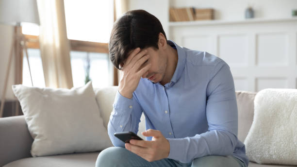 istock Upset man get unpleasant message on smartphone 1247647763