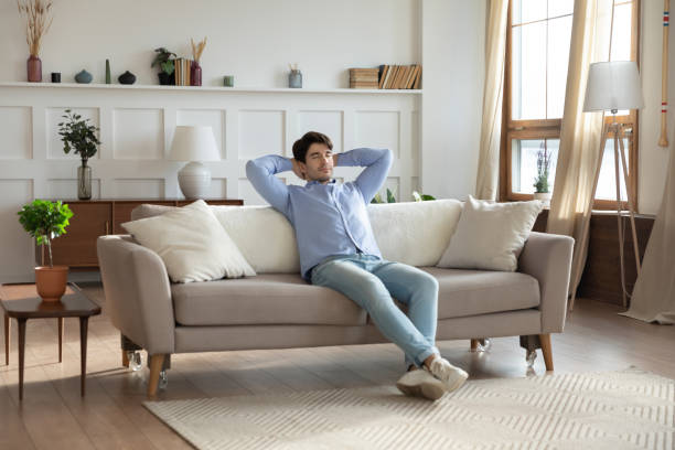 istock Young caucasian man relax on sofa in design living room 1247647771
