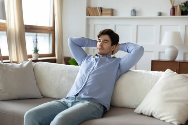istock Calm caucasian man relax on sofa at home daydreaming 1247647775