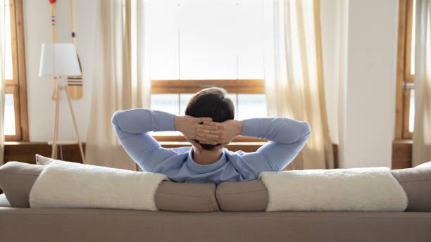 istock Back view of man relaxing on cozy couch 1247647783