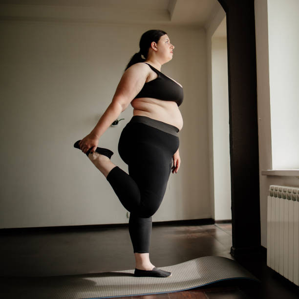 istock overweight woman doing stretching exercise at home 1247650120