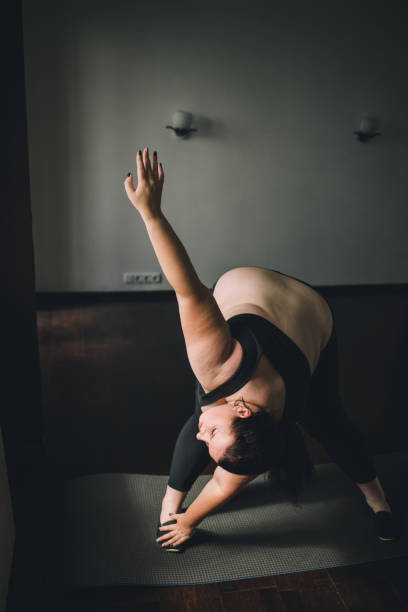 istock overweight woman doing stretching exercise at home 1247652145