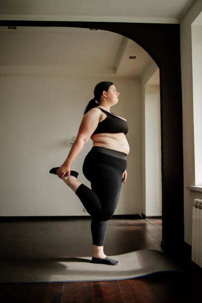 istock overweight woman doing stretching exercise at home 1247652154