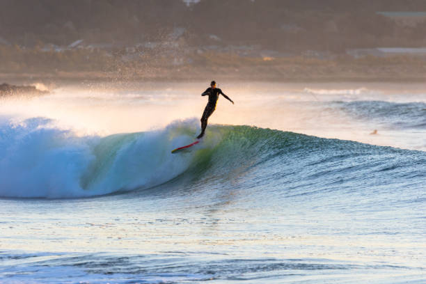 istock Man surfs waves on a beach near Tokyo just after a Typhoon has passed. 1247656354