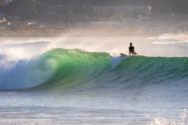 istock Man surfs waves on a beach near Tokyo just after a Typhoon has passed. 1247656377