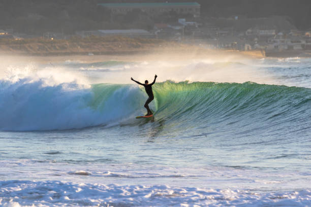 istock Man surfs waves on a beach near Tokyo just after a Typhoon has passed. 1247656385
