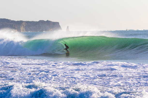 istock Man surfs waves on a beach near Tokyo just after a Typhoon has passed. 1247656398