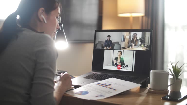 Asian Businesswoman having Video call meeting with team at home