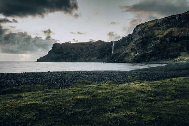 istock Rainy and cloudy day at the Talisker Beach waterfall 1247659290