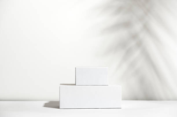 White empty stands on light shadow background. Blank unbranded shopfront. Showcase for cosmetic products. Product advertisement. Copy space. Cosmetology and beauty concept