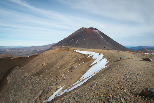 View of Mount Ngauruhoe in the distance with one person on the track on the Tongariro Alpine Crossing