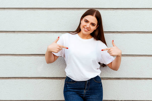 istock girl wearing a white t-shirt standing on a grey wall background 1247673921