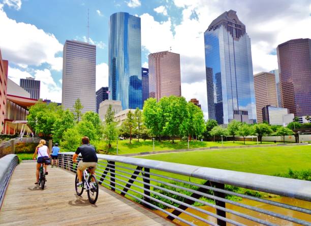 casal andando de bicicleta através da ponte no centro de houston park - cycling bicycle healthy lifestyle green - fotografias e filmes do acervo