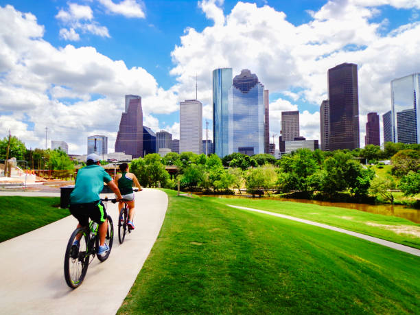 Couple Riding Bikes on Path in Downtown Houston Park stock photo
