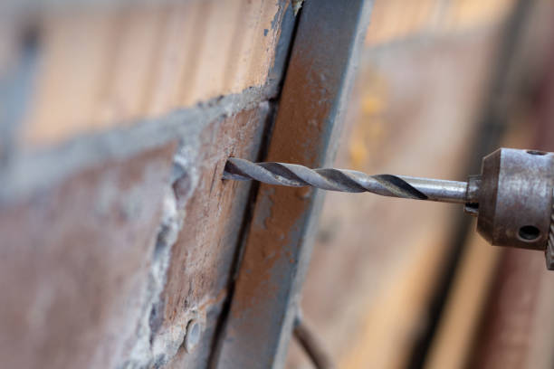 istock Drilling hole in a brick wall close up 1247687508