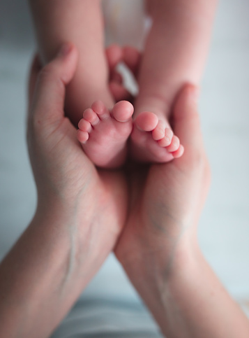 Woman hands holding baby feet closeup with copy space