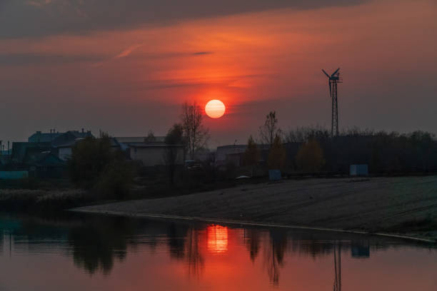 belo pôr-do-sol laranja-vermelho com o sol no lago na parte da cidade, há um ventilador de vento nas proximidades - romantic sky audio - fotografias e filmes do acervo