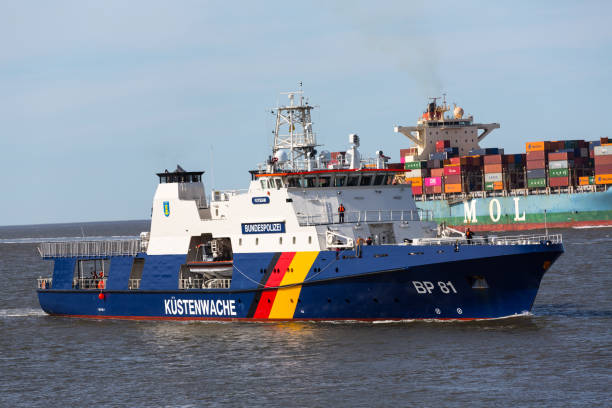 Cuxhaven, 2 June 2010. The 86m Patrol Vessel Potsdam near Cuxhaven port. The Potsdam is operated by the Bundespolizei, Germany, and was delivered in 2019 from the Fassmer shipyard. The vessel has a helicopter landing deck, helicopter refueling station, and two interceptor boats. At the background the container vessel MOL Guardian is passing on the way to Hamburg along the Elbe river.