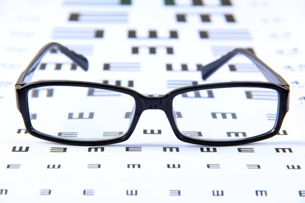 anteojos en una tabla de pruebas de vista ocular - doctor reading chart human eye fotografías e imágenes de stock