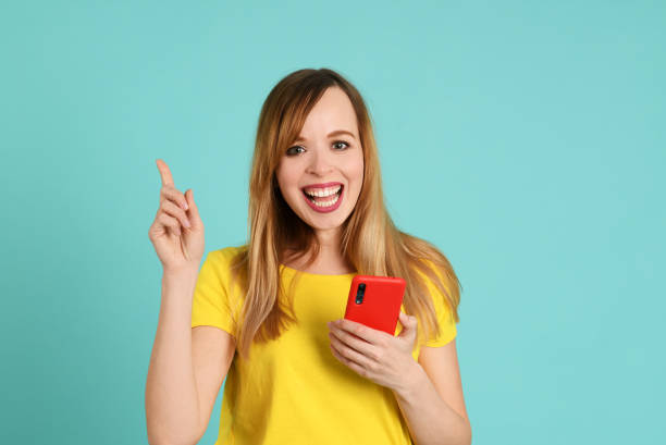 istock Cheerful young woman using smartphone 1247699169