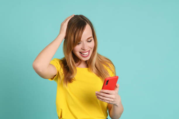 istock Cheerful young woman using smartphone 1247699184