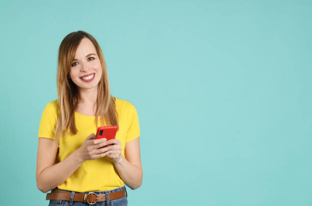 istock Cheerful young woman using smartphone 1247699185
