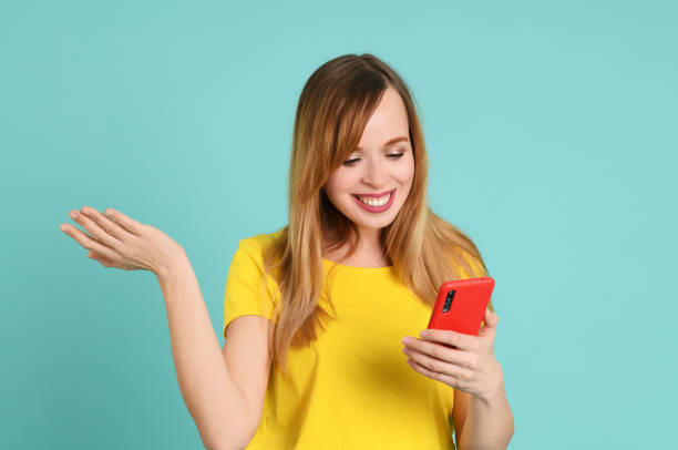 istock Cheerful young woman using smartphone 1247699208