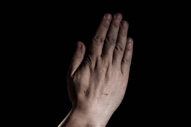 istock Praying hands of a white man on black background 1247701860