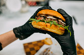 juicy burger with a cutlet in the hands in gloves
