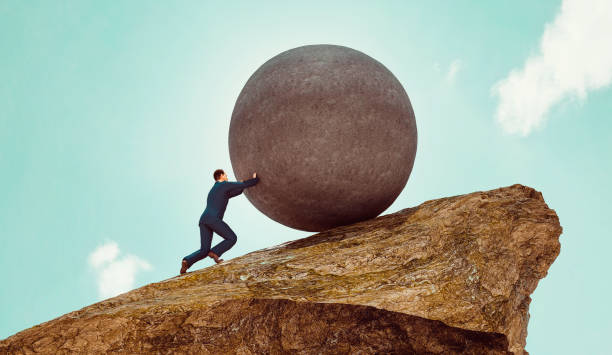 Man wears business suit and pushes big rock up a hill Concept of business work. Man stands on a hill and uses his strength to push a big rock up the steep hill side. Pushing a rock up hill is also a reference to the greek mythology Sisyphus ot Sisyphos.
Note: The man is a 3D-render with face scan. Model release attached. rolled up sleeves stock pictures, royalty-free photos & images