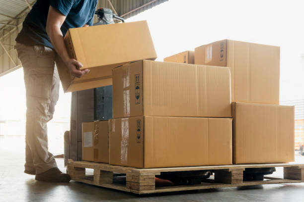 el servicio de mensajería de los trabajadores levanta cajas de carga apilándose en el palet. - pesado fotografías e imágenes de stock