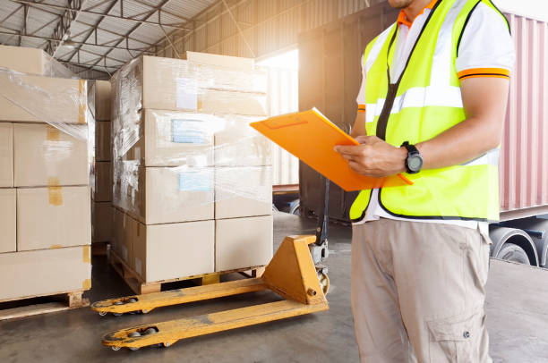istock Cargo freight industry warehouse shipment transportation. Worker holding clipboard checking in checklist to loading shipment goods into container truck. 1247733271
