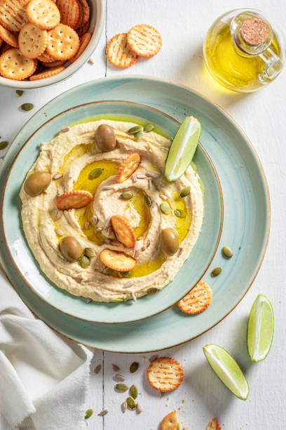 istock Tasty hummus with olives and round crackers 1247735329
