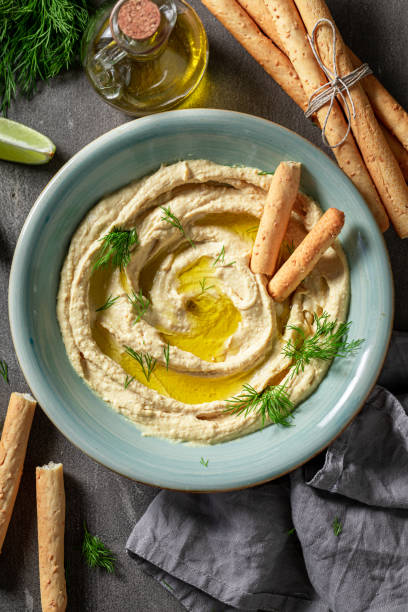 istock Tasty and fresh hummus with breadsticks and dill 1247735414