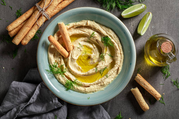 istock Yummy and traditional hummus with breadsticks and dill 1247735956