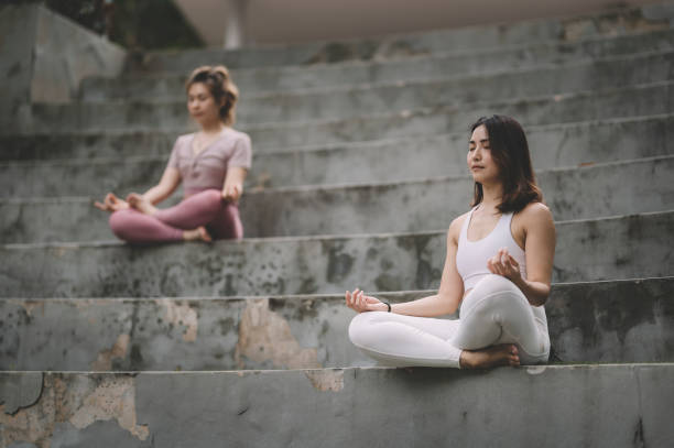 2 azjatyckie chiński chiński przyjaciel trening w publicznym parku w medytacji jogi rano - spirituality yoga zen like meditating zdjęcia i obrazy z banku zdjęć