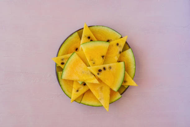 istock Sliced yellow watermelon on pink background. Top view 1247760428
