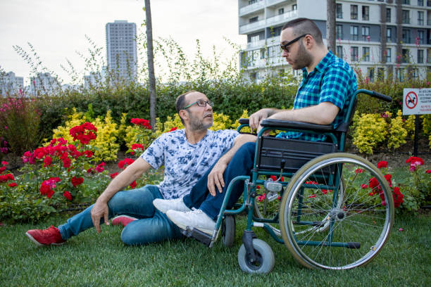 istock Handicapped boy spending time with his father in a wheelchair 1247770627