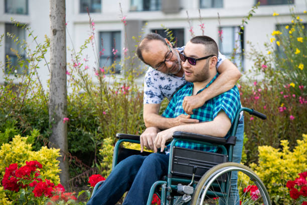 istock Handicapped boy spending time with his father in a wheelchair 1247770664