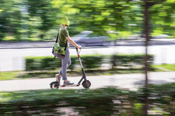 istock Man with protective mask riding e-scooter on the street 1247771053
