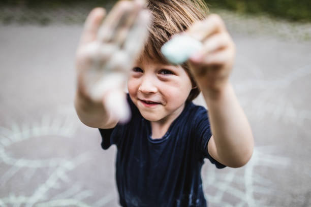 Toddler boy chalking on the street