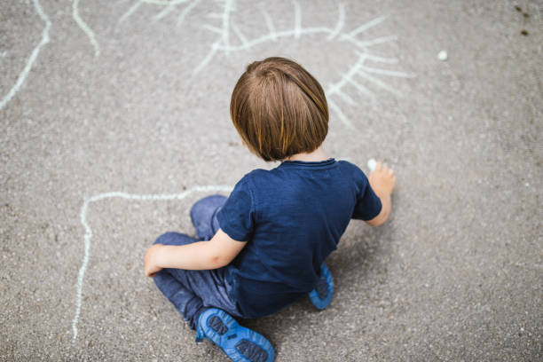 istock Toddler boy chalking on the street 1247773301