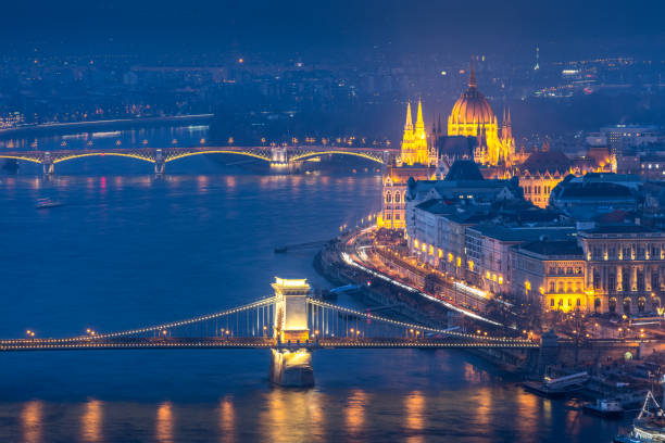 vista aérea do edifício do parlamento húngaro e ponte da cadeia de szechenyi, budapeste durante o crepúsculo - budapest chain bridge panoramic hungary - fotografias e filmes do acervo