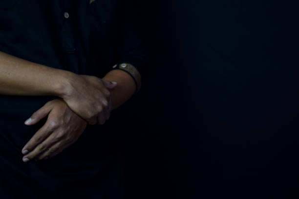 istock Young man praying with arms across posture. Islamic praying concept on black background. Selective focus on finger 1247773710
